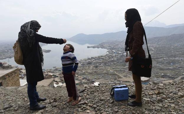 Un médico afgano sumistra la vacuna antipoliomielítica a un niño en Kabul.