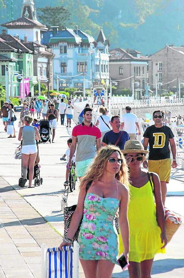 Numerosos turistas pasean junto a la playa de Santa Marina. / E. C.