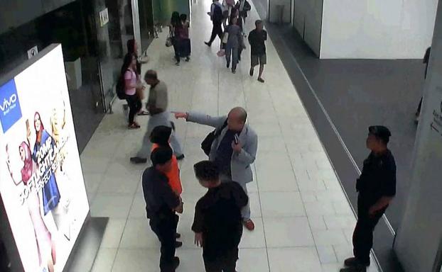 Kim Jong-Nam (c) habla con el personal de seguridad del aeropuerto de Kuala Lumpur./