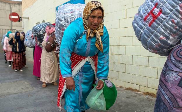 Varias mujeres cargan con grandes fardos en la frontera afroespañola. /FADEL SENNA (AFP)