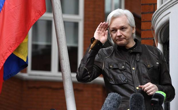 Assange saluda desde la entrada de la embajada de Ecuador. /Facundo Arrizabalaga (Efe)