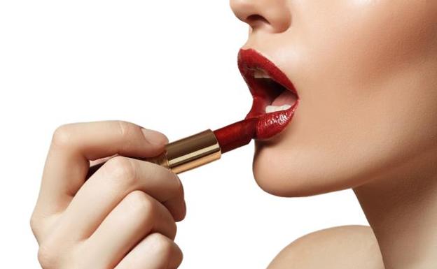 Una mujer se pinta los labios./