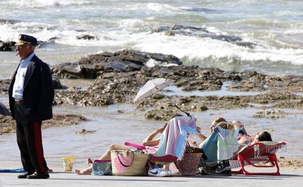 Un grupo de mujeres, disfrutando de la jornada de calor en la playa de San Lorenzo de Gijón./D. ARIENZA