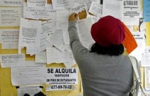 Una joven asturiana ojea anuncios de alquiler de pisos en el tablón de anuncios de un establecimiento comercial. :: LVA/