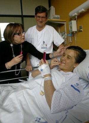 Gloria intenta maquillarse con la ayuda de su prima Yolanda «para salir guapa en la foto». Detrás, el doctor Ignacio González-Pinto, cirujano que dirigió el trasplante. :: MARIO ROJAS/