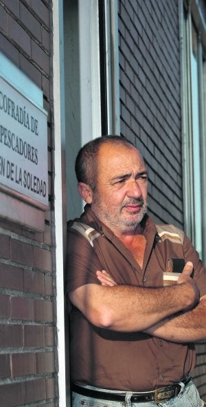 Jesús Teleña, ayer, en El Musel, apoyado en la puerta de la Cofradía de Pescadores Virgen de la Soledad. ::
ALEX PIÑA/