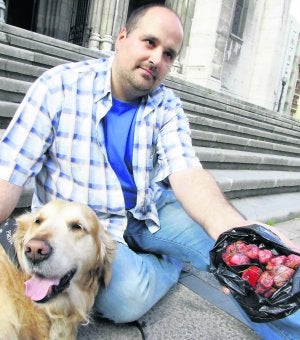 Pablo Mesa Iglesias muestra, junto a 'Hutch', parte de la carne y salchicas envenenadas que retiró del parque. :: SERGIO LÓPEZ/
