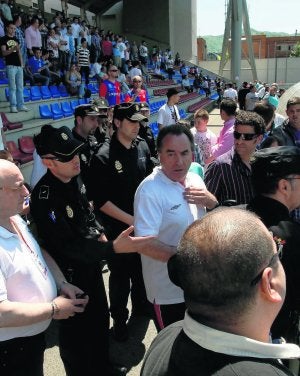 Daniel Suárez, rodeado de policías nacionales, tras protagonizar un altercado con un aficionado. ::
J. M. PARDO/