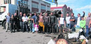 Los participantes en la limpieza del puerto de Cudillero, con los restos de basura que fueron depositando en un camión. :: GRUPO ENSIDESA DE ACTIVIDADES SUBACUÁTICAS/