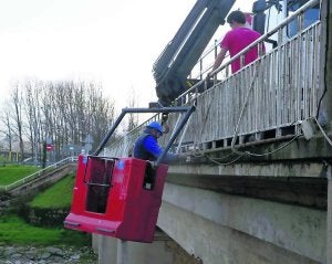 Un operario trabaja en la mejora de las vallas del puente. ::
N. ACEBAL/