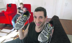 Imagen de archivo de Anthony Hecht mostrando las zapatillas con las que corrió el maratón de Londres con fines solidarios; tras él su esposa, Cristina Suárez Mariño y su hija. :: MARIETA/