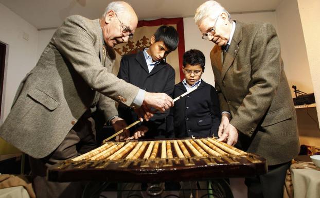 Francisco Martínez y Blas Cabello, en su día Niños de San Ildefonso, posan con dos de los niños que cantarán el sorteo de la Lotería de Navidad 2010. /José Ramón Ladra