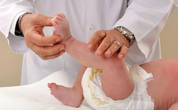 Un médico atiende a un bebé en la consulta./Fotolia