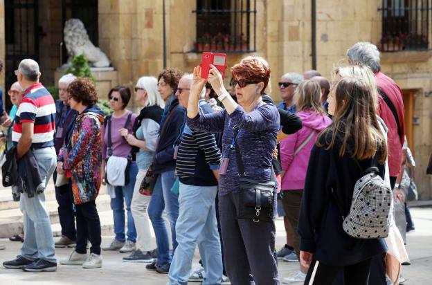 Un grupo de turistas hace fotografías durante su paseo por Oviedo. / ÁLEX PIÑA