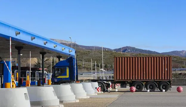 Un transporte de contenedores ante las cabinas de peaje de la autopista del Huerna. / DAMIÁN ARIENZA