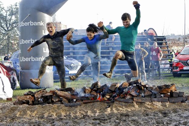 Tres participantes saltan sobre el fuego en la edición del año pasado. / A. GARCÍA