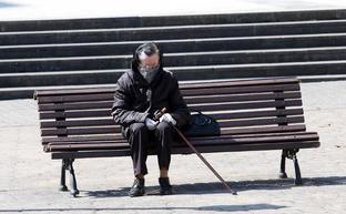 Una anciana descansa en un banco de la calle Palmira Villa, en Pumarín ./ALEX PIÑA