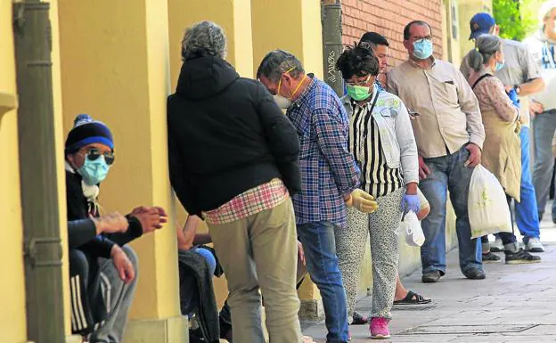 Usuarios de la Cocina Económica de Oviedo hacen cola para recibir alimentos./mario rojas