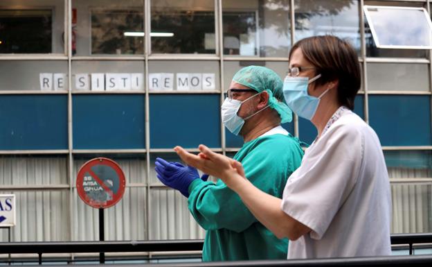 Sanitarios aplauden junto a la puerta de urgencias de un hospital de Salamanca./EFE
