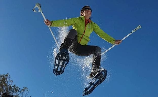 Almudena Suárez saltando sobre la nieve con sus raquetas