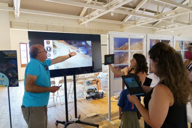 I partecipanti alla visita guidata della mostra ascoltano le spiegazioni di Marcos Alvarez. 